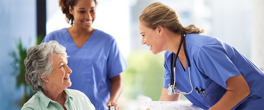 A senior woman smiling with skilled nurses.